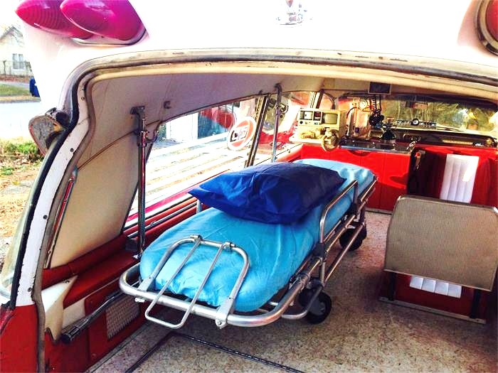 A period patient stretcher is stowed in back