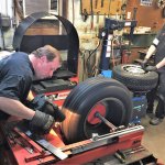 OBrien works the tire lathe while Mark Clausen checks the valves stems