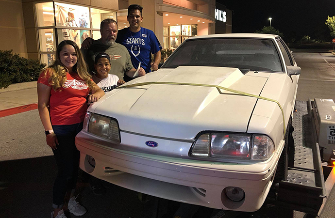 siblings-buy-back-dad's-ford-mustang-sold-mom-cancer-medical-bills The Ryan family poses with their dad's 1993 Ford Mustang he sold 17 years ago to pay their mother's medical bills. Now cancer-free, she helped her children surprise their father with the gift. | Facebook photo