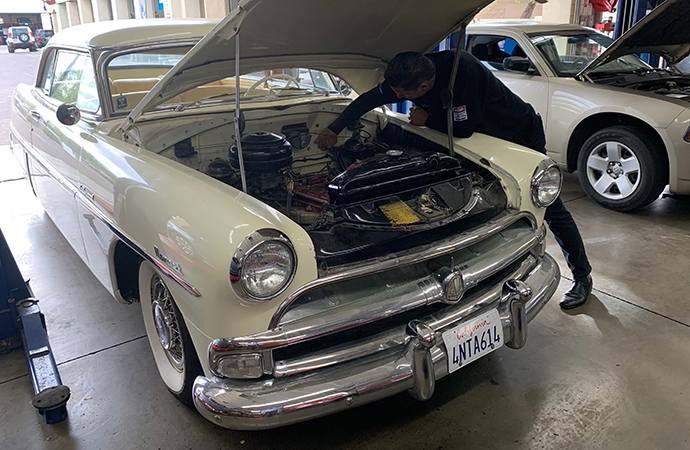 Frank Leutz inspects the engine of a Hudson Hornet that's been in storage. Classic car owners should check at least 11 things before driving their car after a long, hot summer. | Carter Nacke photo