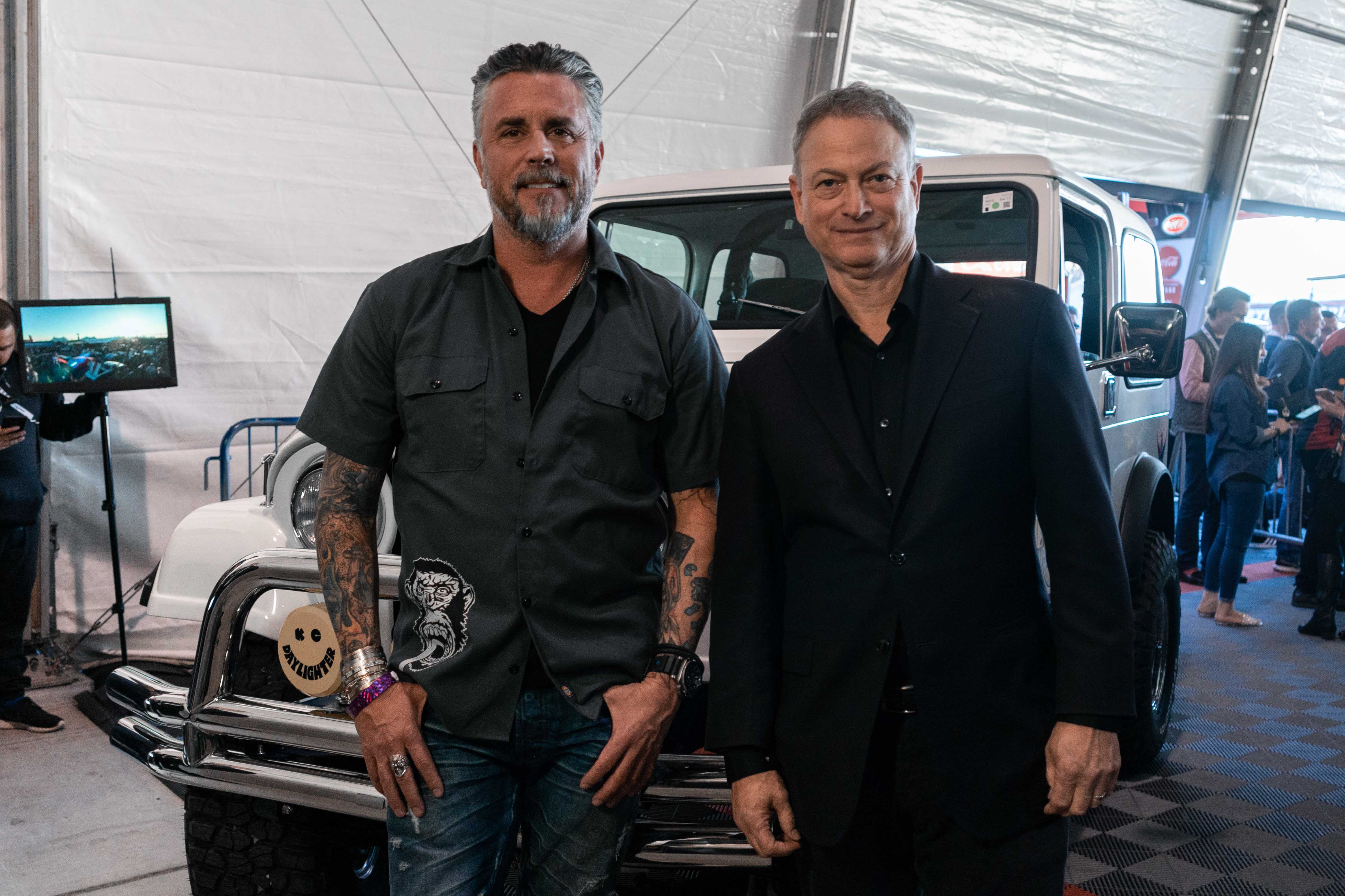 Sinise (right) and Rawlings pose near the Jeep as it was readied to go on the block.